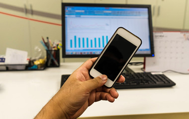 hold smartphone in font of desktop