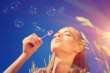 Obraz premium Pretty woman blowing soap bubbles