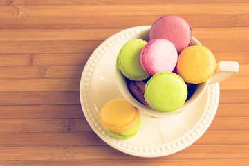 Some macaroons at white tea cup, toned