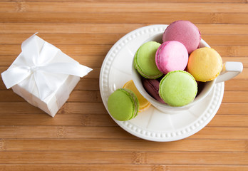 Some macaroons at white tea cup and gift box