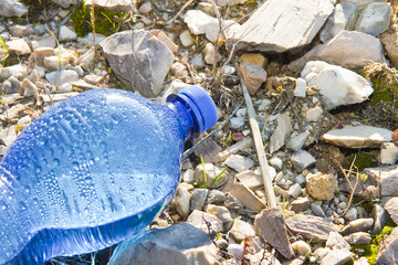 Obraz premium Abandoned blue plastic bottle of water - concept image