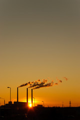 Fototapeta premium Sunset for industrial buildings with smoking pipes