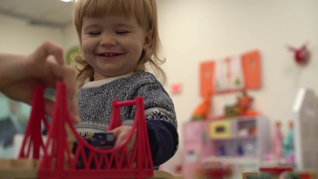 4K Activities in the kindergarten, the baby is playing with a wooden toy road