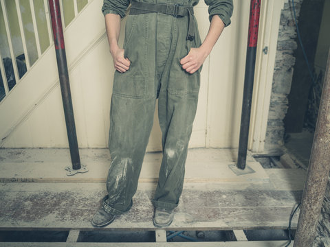 Person in boiler suit in house undergoing renovations