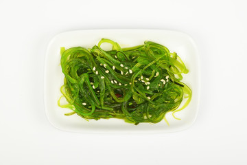 Seaweeds salad on small white dish plate