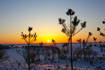sunset on the shore of of winter river