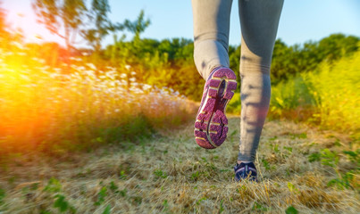Woman running at sunset in a field