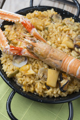 Vegetable paella with seafood on a wooden background