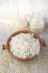 Cooked steamed rice in a blue bowl over wooden background