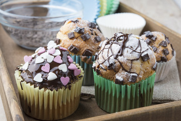 Photo of tasty cupcakes with chocolate over wooden table