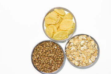 Cereals on a white background: buckwheat, oatmeal, cornflakes