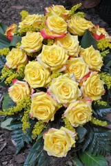 Blumen der Trauer auf dem Friedhof - gelbes Rosengebinde