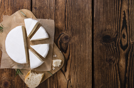 Pieces of Camembert on wooden background