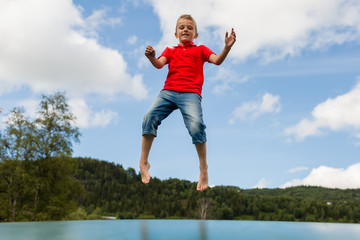 Young boy jumping on bouncing pillow