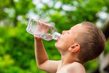 Child drinking clean tap water from transparent plastic bottle - obrazy, fototapety, plakaty