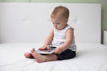 Infant child baby toddler sitting and typing digital tablet comp