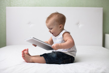 Infant child baby toddler sitting and typing digital tablet comp