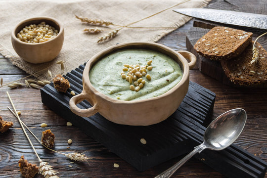 Broccoli cream soup with pine nuts and wholemeal bread, ears of corn, rustic