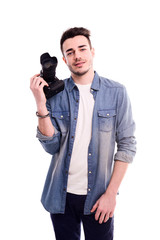 isolated portrait of handsome young man photographer posing and holding a camera