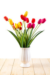 Red and Yellow and Pink tulips in pot on wood texture isolated o