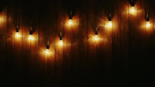 Garland of electric bulbs on a wooden background