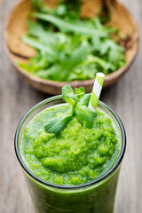 Rucola smoothie, on the grey  background.