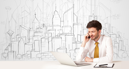 Businessman sitting at the white table with hand drawn buildings