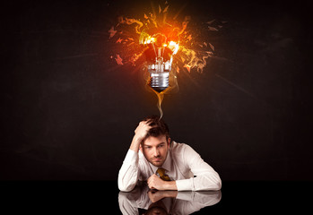Businessman sitting under a blowing idea bulb