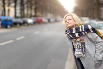 Attractive blond woman waiting for a cab or a lift