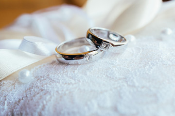 Obraz na płótnie Canvas Wedding rings on the lace pillow