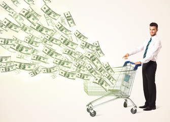 Businessman with shopping cart with dollar bills