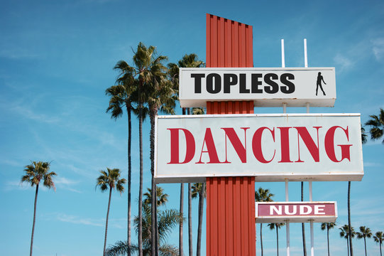 aged and worn vintage photo of exotic dancing sign with palm trees