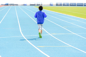 Fototapeta na wymiar Boy run in blue track