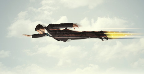 Happy business man flying fast on the sky between clouds
