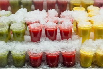 Cold, fresh kiwi, berry and pineapple fruit juice in plastic cup