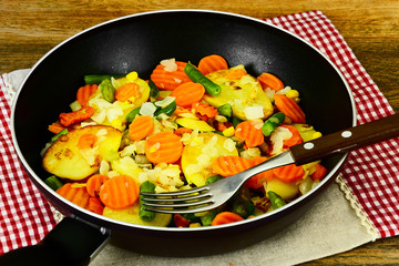 Steamed vegetables potatoes, carrots, corn, green beans and onio