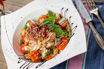 Tasty grilled chicken salad with rucola, cherry tomatoes, valeri