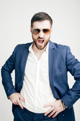 Handsome young bearded man in a business suit emotionally shouts