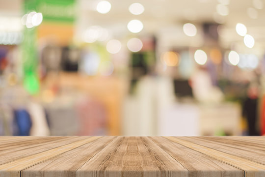 Wooden board empty table blurred background. Perspective brown wood over blur in department store - can be used for display or montage your products.Mock up for display of product.