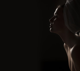 Silhouette profile of a beautiful young woman with a towel on her head