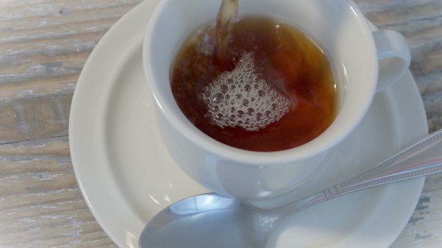 Pour tea into a cup 4K