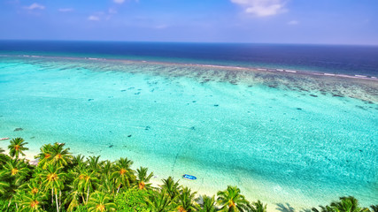 Shoreline of a tropical island in the Maldives and view of the I