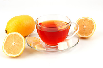 Glass cup of tea surrounded by lemons.