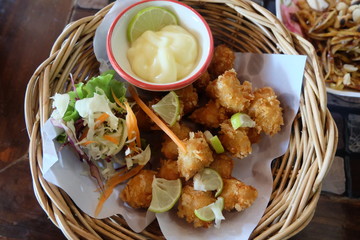 Crispy chicken with lemon sauce on basket 
