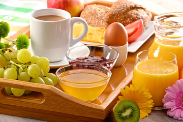 Breakfast on tray served with coffee, juice, egg, and rolls