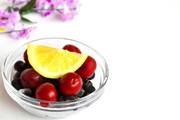 Frozen cherries and black currants, a slice of fresh lemon