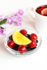 Frozen cherries and black currants, a slice of fresh lemon, Cup of compote