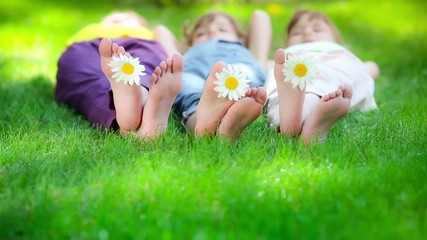 Family lying on grass outdoors in spring park - Powered by Adobe