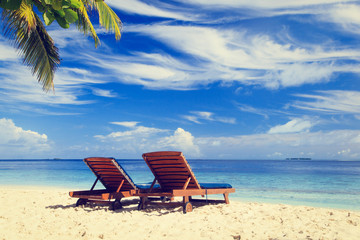 Fototapeta na wymiar Two beach chairs on the tropical vacation