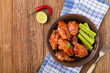 Baked chicken wings in honey sauce sprinkled with sesame seeds.